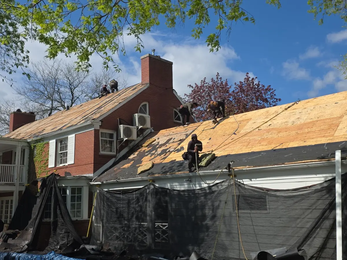 Crew stripping a roof down to the decking during a full tear off