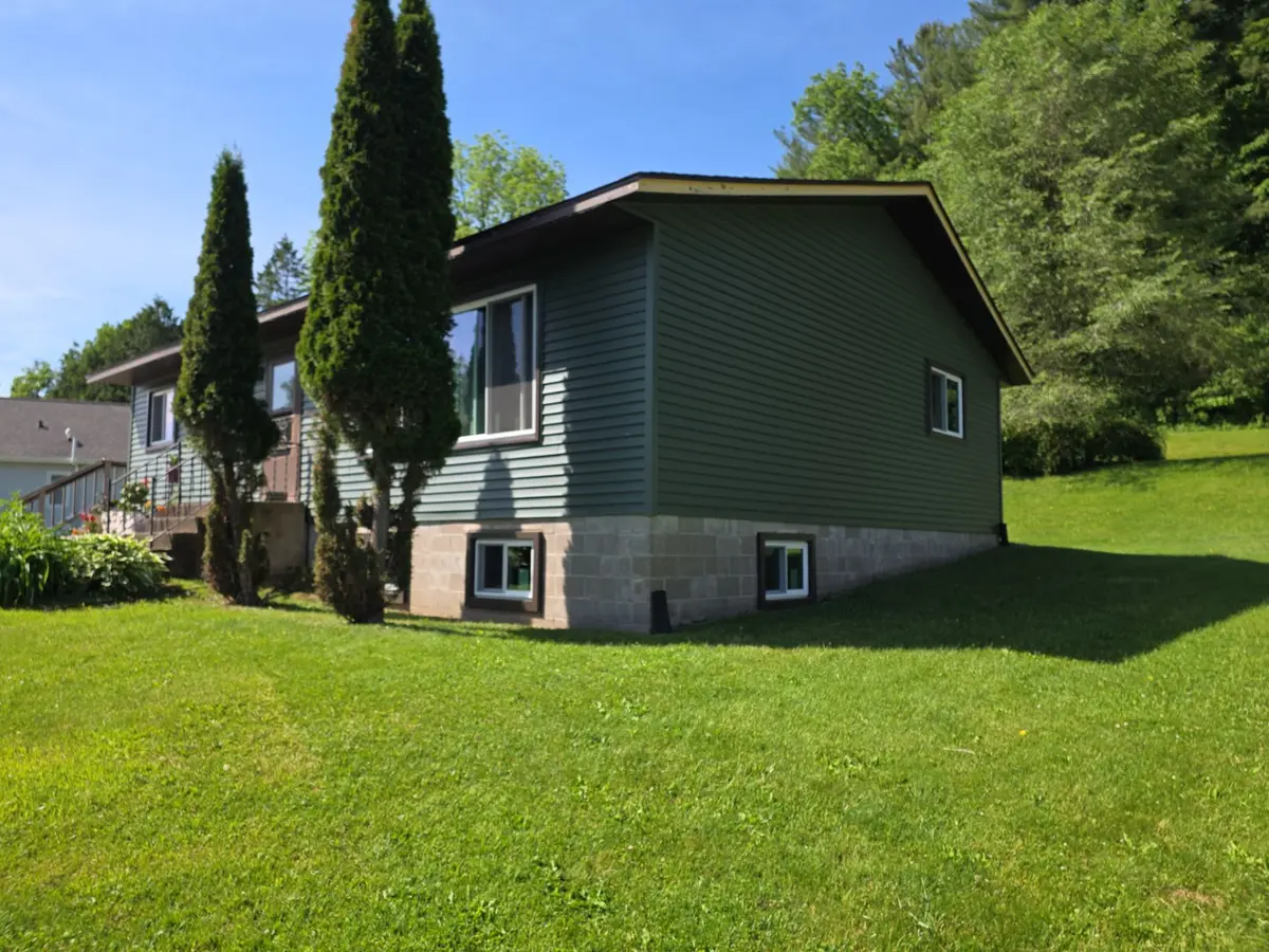 Green lap siding newly installed on a split level home over a block foundation